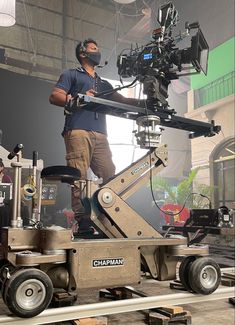 a man standing on top of a truck with a camera attached to it's side