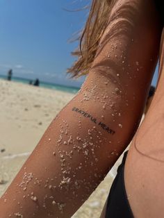 a woman's arm with white sand all over it