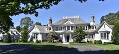 a large white house sitting on top of a lush green field