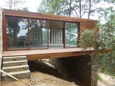 a house built into the side of a hill with stairs leading up to it's entrance