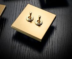 two light switches sitting on top of a black table