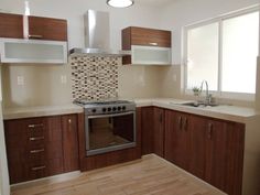 an empty kitchen with wood cabinets and stainless steel stove top oven, microwave and dishwasher