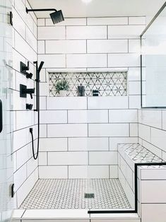 a white tiled bathroom with black and white fixtures