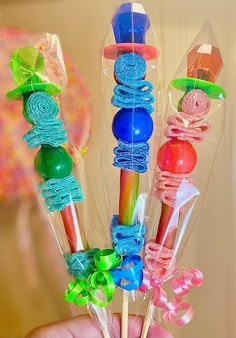 a person is holding several colorful lollipops in their hand and they are wrapped in cellophane