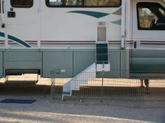 an rv parked on the side of the road with stairs leading up to it's door