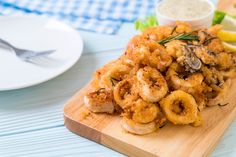 a wooden cutting board topped with fried shrimp