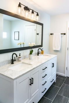 a bathroom with two sinks and a large mirror over it's counter top area