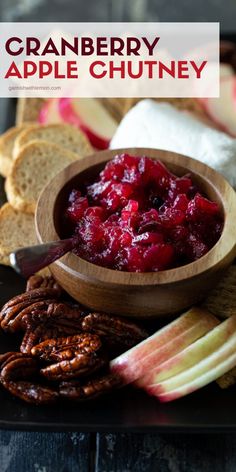 cranberry apple chutney in a wooden bowl surrounded by apples and pretzels