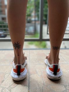 the legs and ankles of a person with tattoos on them, both wearing white shoes