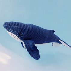 a knitted whale toy floating in the air