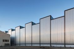 an industrial building with several windows on the side of it and no one standing outside