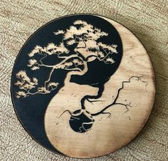 a wooden plate with a tree and a man's face in the shape of a yin - yang