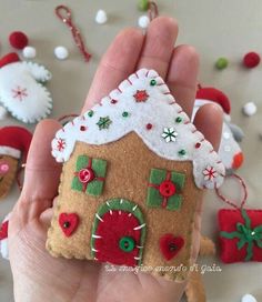 a hand holding a small gingerbread house ornament