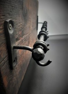 an iron hook on the side of a wooden door