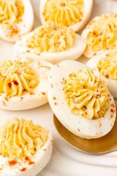 deviled eggs on a plate with mustard sprinkled on them