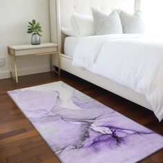 a white bed sitting next to a wooden floor