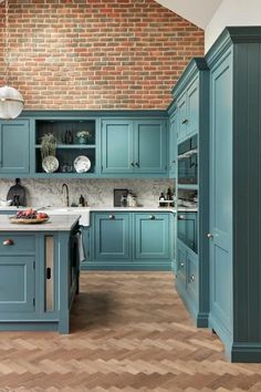 a kitchen with blue cabinets and wooden floors