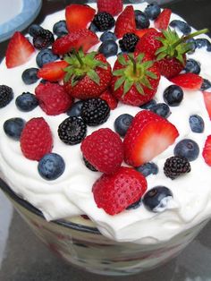 a cake with strawberries, blueberries and raspberries on top