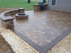 a brick patio with benches and fire pit