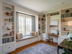 a living room filled with lots of furniture and bookshelves next to a window