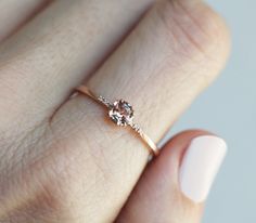 a woman's hand with a gold ring and two diamond stones on the band