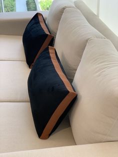 two black and brown pillows on a white couch