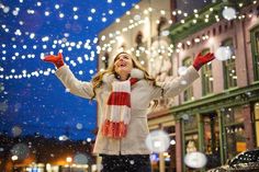 a woman standing in the snow with her arms outstretched