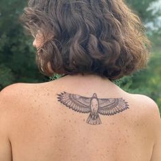 the back of a woman's body with a bird tattoo on her left shoulder