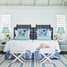 two beds in a bedroom with blue and white decor