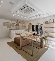 a clothing store with lots of items on display and lights hanging from the ceiling above