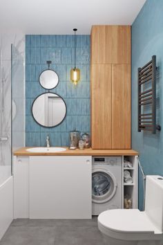 a washer and dryer in a bathroom next to a toilet with blue tiles on the walls