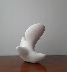 a white sculpture sitting on top of a wooden table