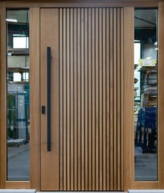 a close up of a wooden door on a building with glass doors and wood slats