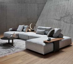 a large sectional couch sitting on top of a hard wood floor next to a table