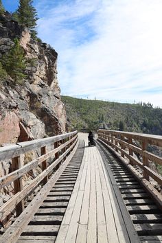 a person riding a motorcycle across a wooden bridge