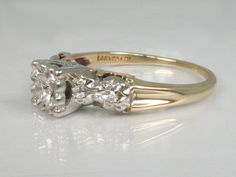 a three stone diamond ring sitting on top of a table