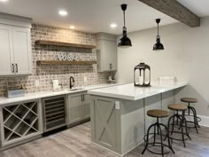 a kitchen with an island, wine rack and bar stools