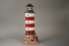 there is a red and white lighthouse statue