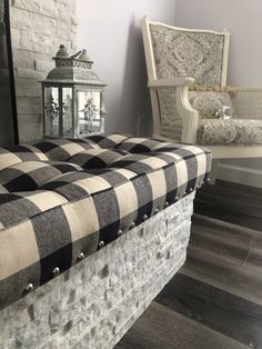 a checkered bench sitting in front of a fireplace with a lantern on the side