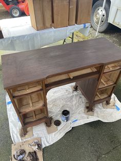 a wooden desk sitting on top of a piece of cardboard