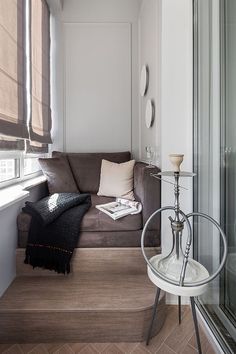 a living room with a brown couch and white walls