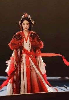 a woman in a red and white dress holding a ribbon