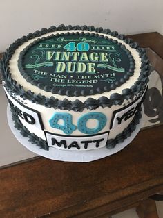 a birthday cake with the words vintage dude written on it, sitting on top of a wooden table