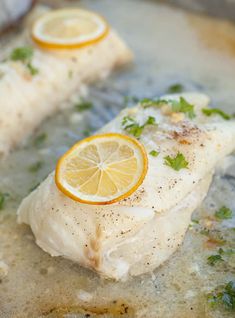 fish with lemon slices and parsley in a pan