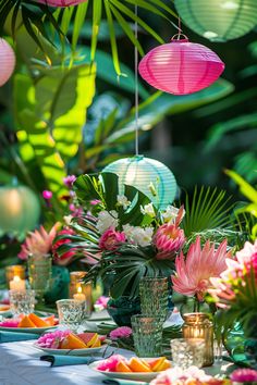 a table topped with lots of plates covered in flowers and paper lantern lights hanging from the ceiling