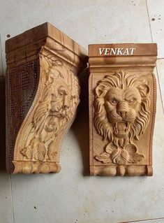 two wooden carvings depicting lions on the side of a wall, one carved from wood