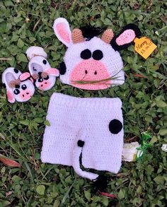 a cow hat and diaper cover laying in the grass