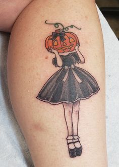 a girl with a pumpkin on her head is wearing a black dress and high heels