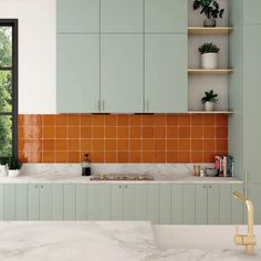 a kitchen with green cabinets and white counter tops, an orange tiled backsplash