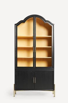 a black and gold bookcase with glass doors